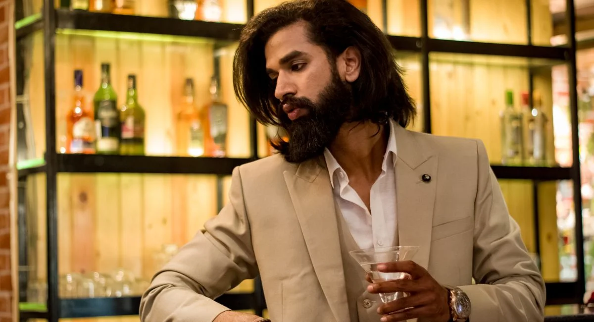 A stylish man with a cocktail in a fashionable bar, exuding elegance and modernity.