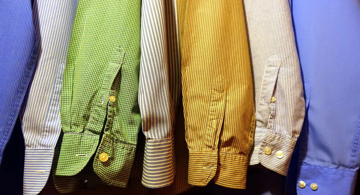 A row of vibrant, striped shirts hanging neatly, showcasing fashion variety.