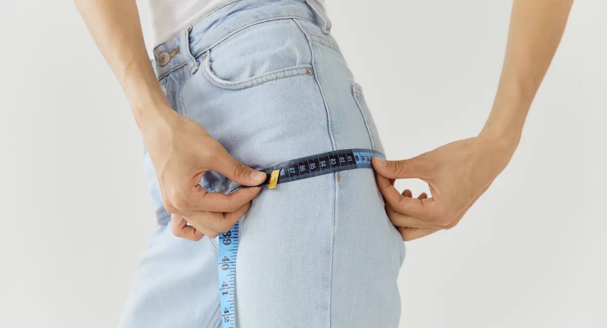 Homme mesurant son tour de taille avec un mètre ruban