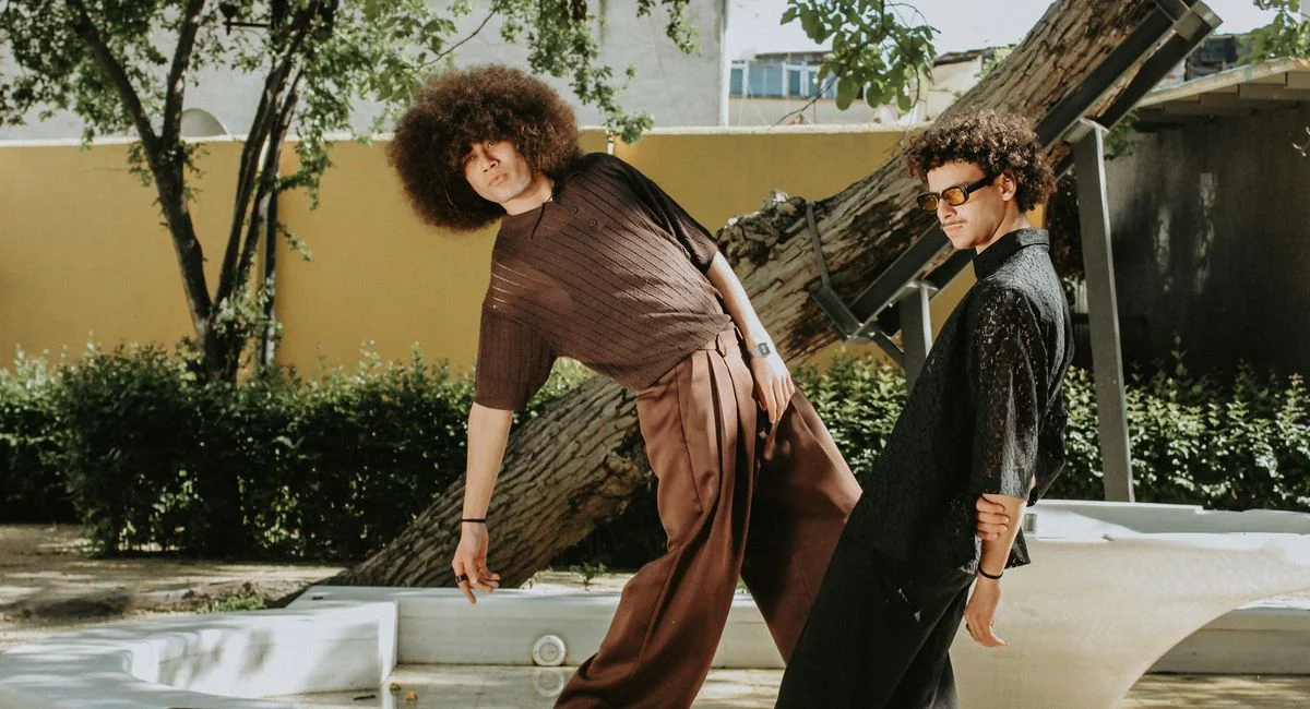 Stylish young men striking a pose outdoors with a vintage aesthetic.