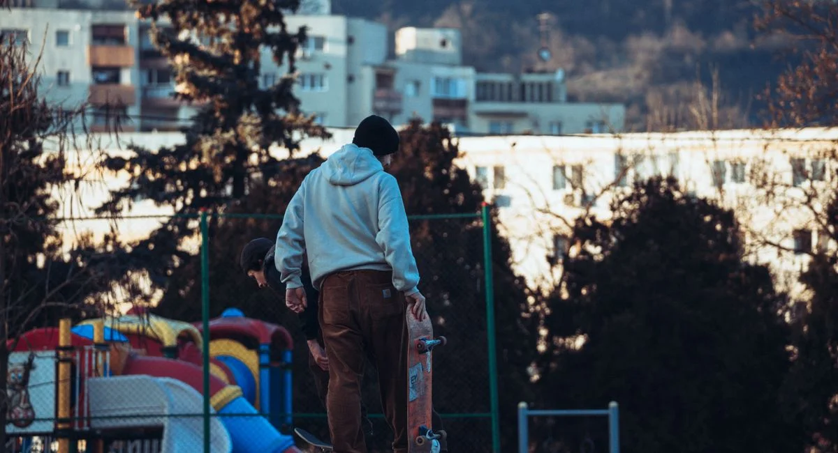 Skateboarders enjoying a skate park in Cluj-Napoca with a scenic urban backdrop.