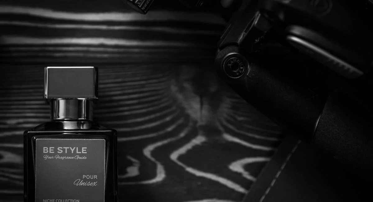 A sleek perfume bottle displayed artistically on a textured wooden background.