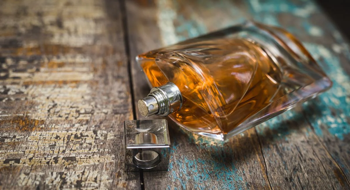 Artistic perfume bottle on rustic wooden surface, perfect for fragrance ads.